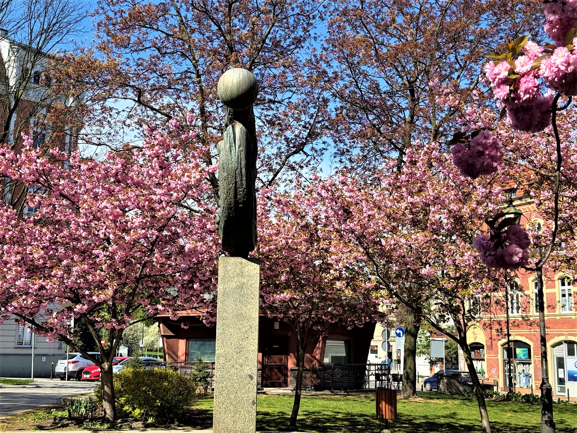 Rzeźba wśród kwitnących na różowo drzewek