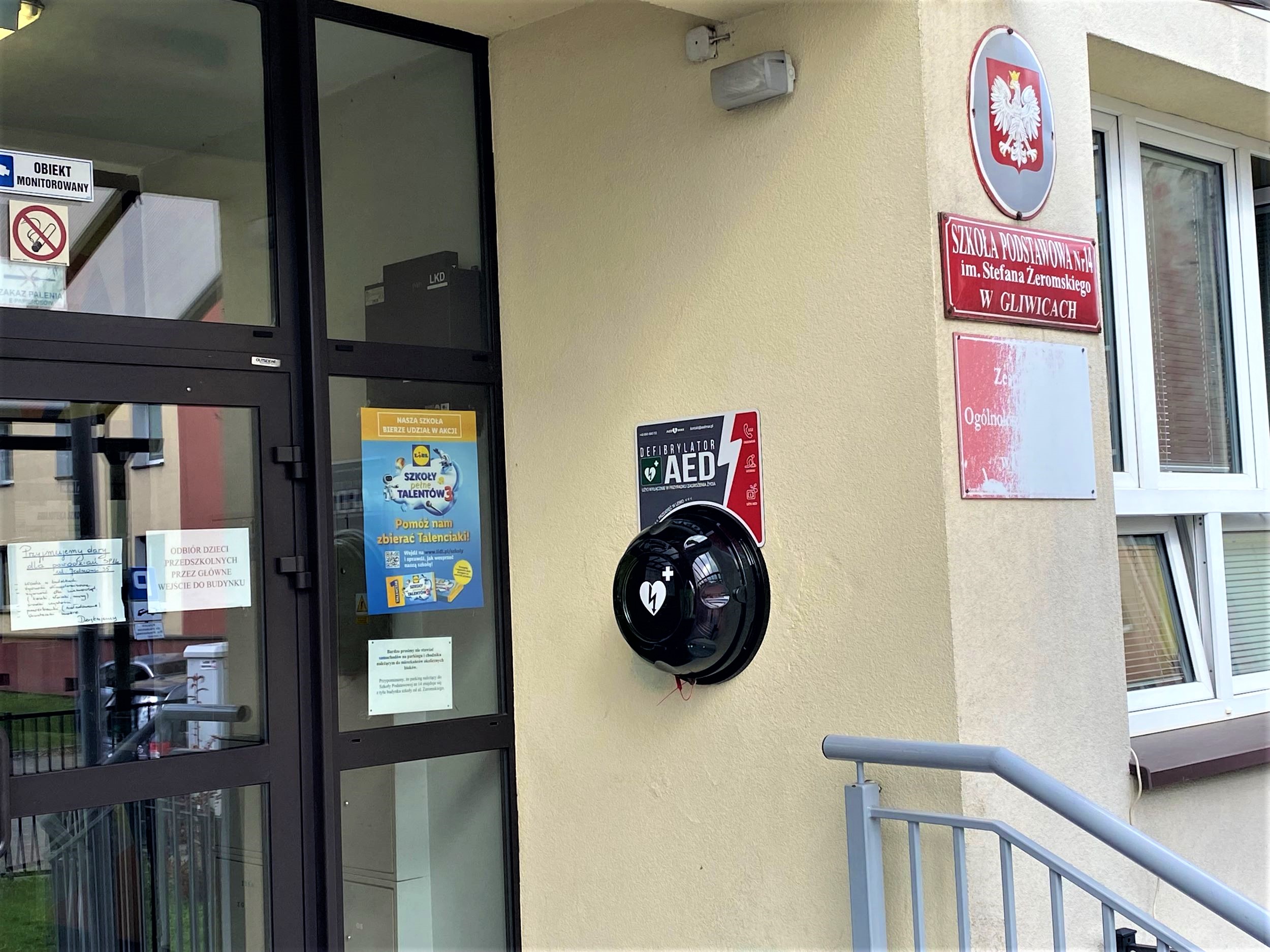 Defibrylatory można spotkać w wielu miejscach, m.in. w Sośnicy na budynku Zespołu Szkół Ogólnokształcących nr 14. Fot. materiały Centrum Ratownictwa Gliwice defibrylator na ścianie szkoły