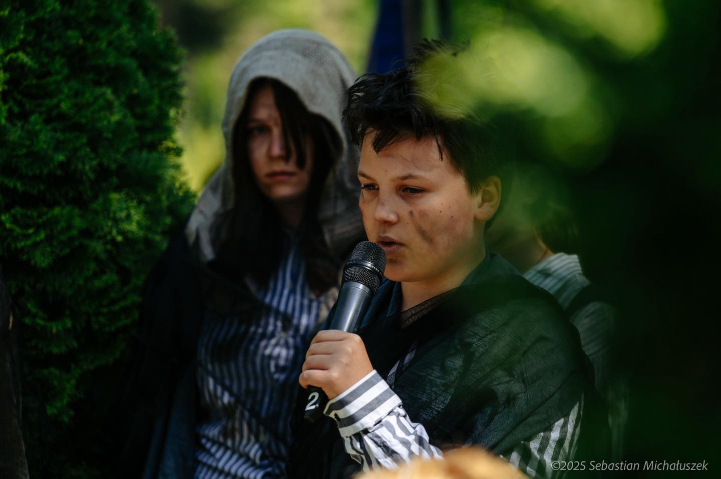 młody człowiek z mikrofonem z opaską na nadgarstku