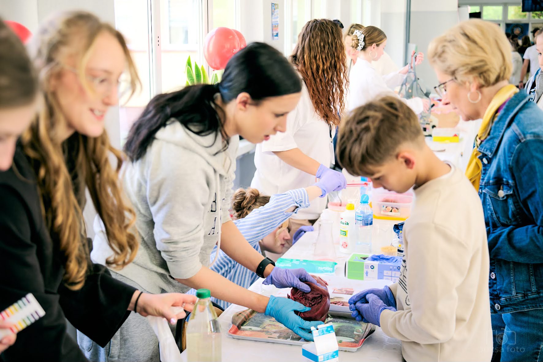 młodzi ludzie przy stoisku z eksperymentami