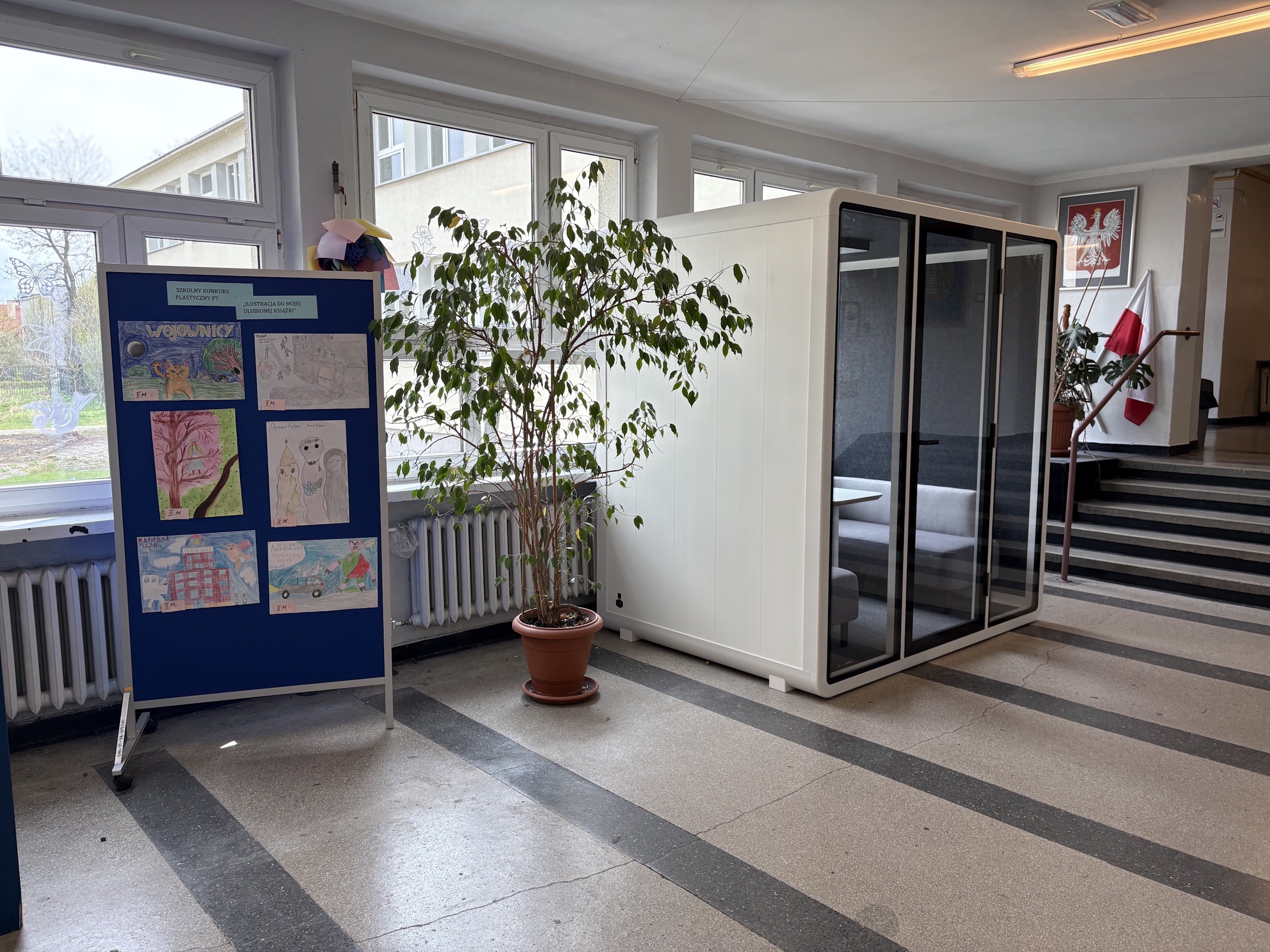 Kabina akustyczna stojąca w szkolnym korytarzu