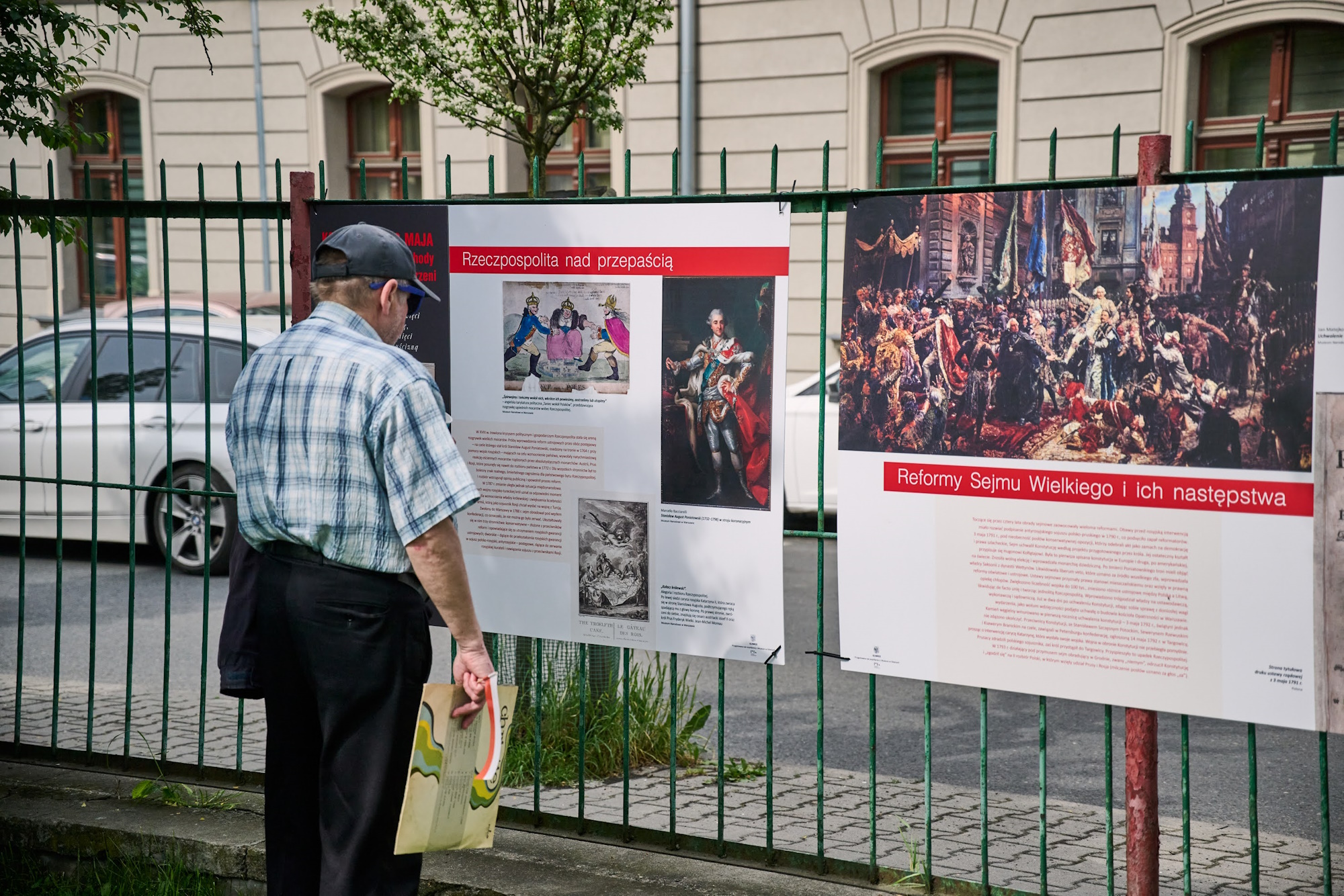 Mężczyzna ogląda plenerową miniwystawę