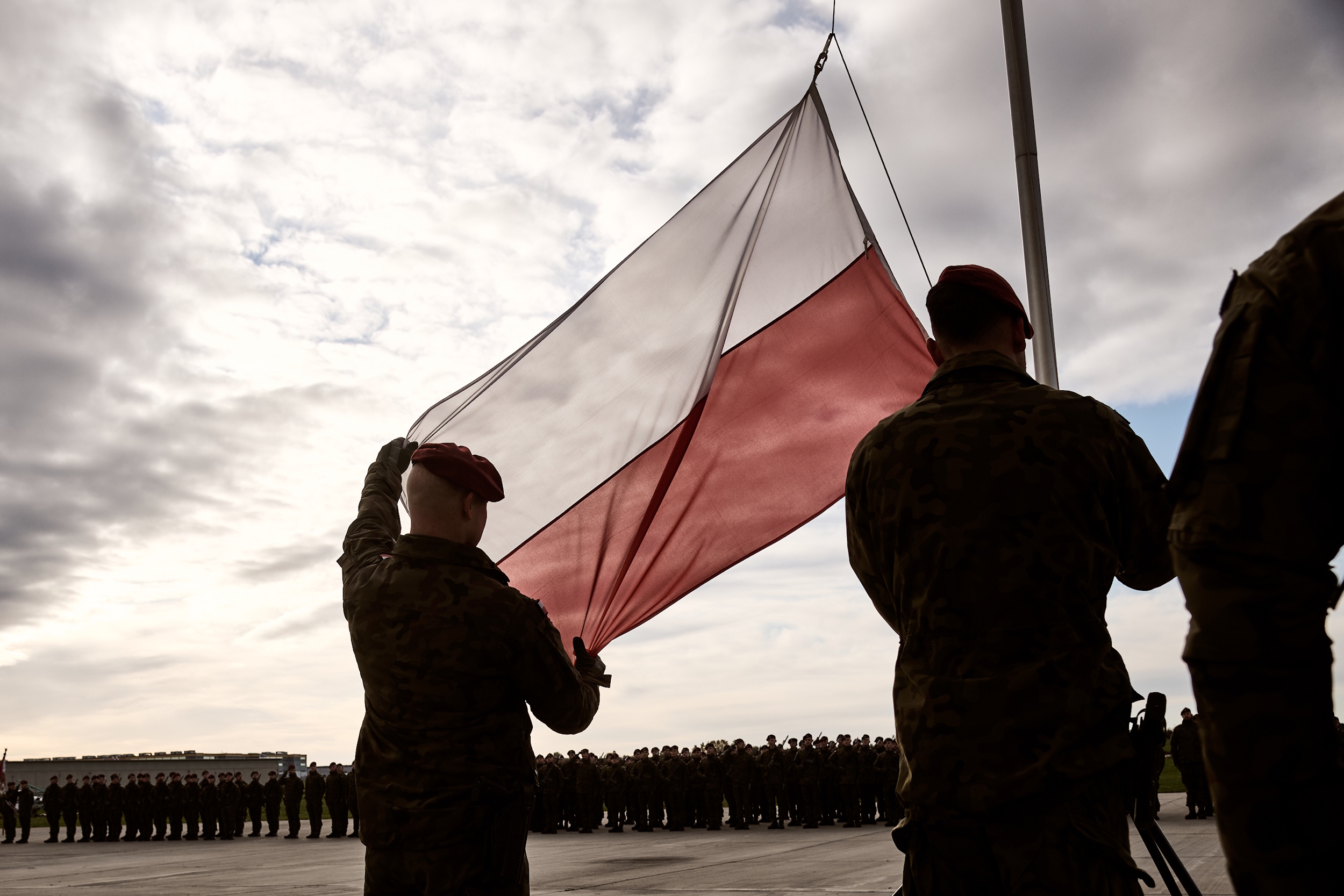Żołnierz trzymający biało-czerwoną flagę
