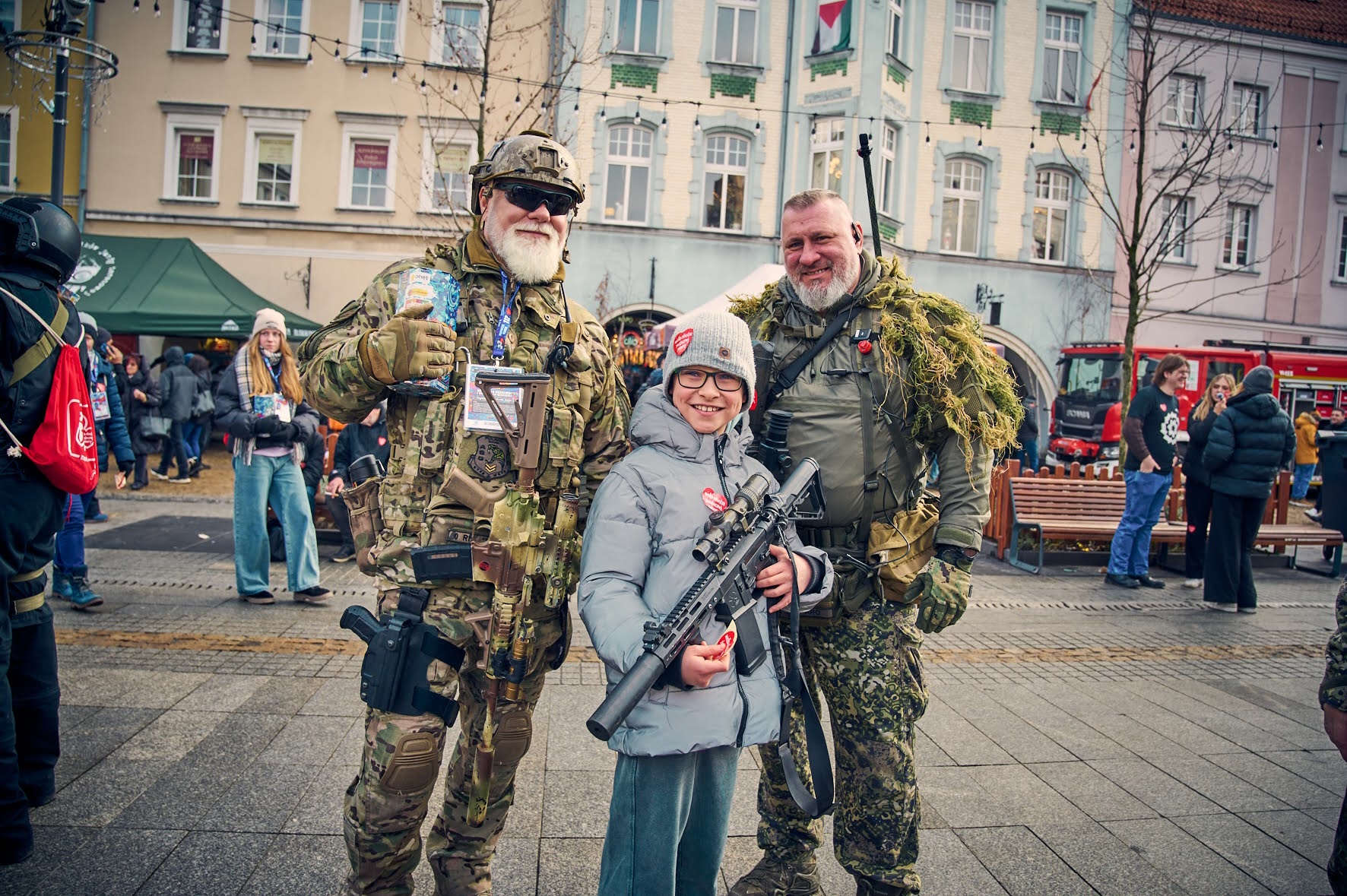 Fot. M. Buksa/UM w Gliwicach Mężczyźni w strojach wojskowych i chłopiec z karabinem pozują do zdjęcia