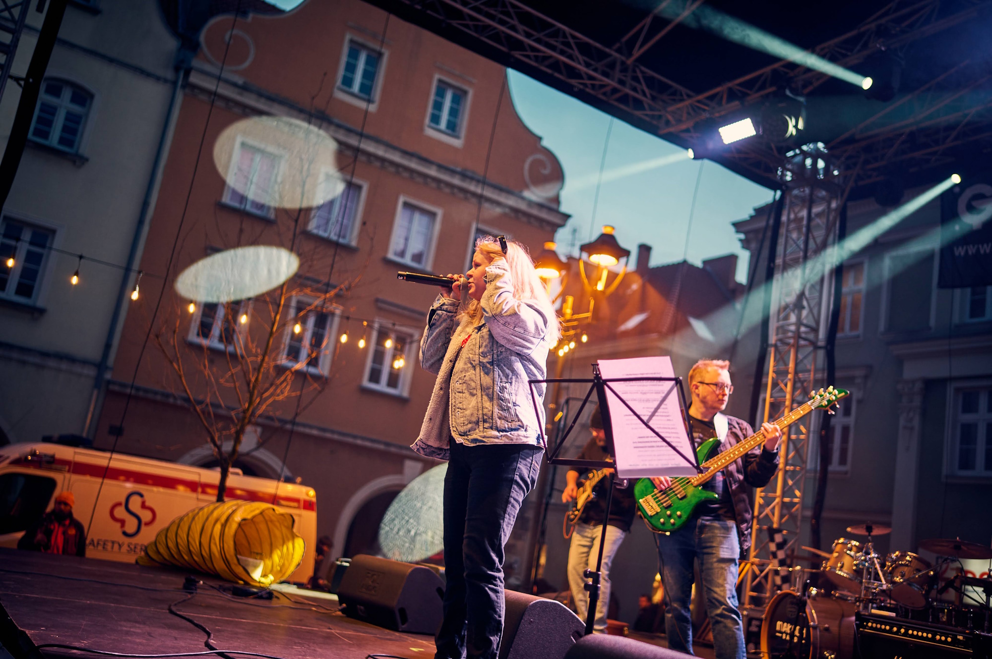 Fot. M. Buksa/UM w Gliwicach Dziewczyna na scenie śpiewa do mikrofonu, za nią mężczyzna z gitarą