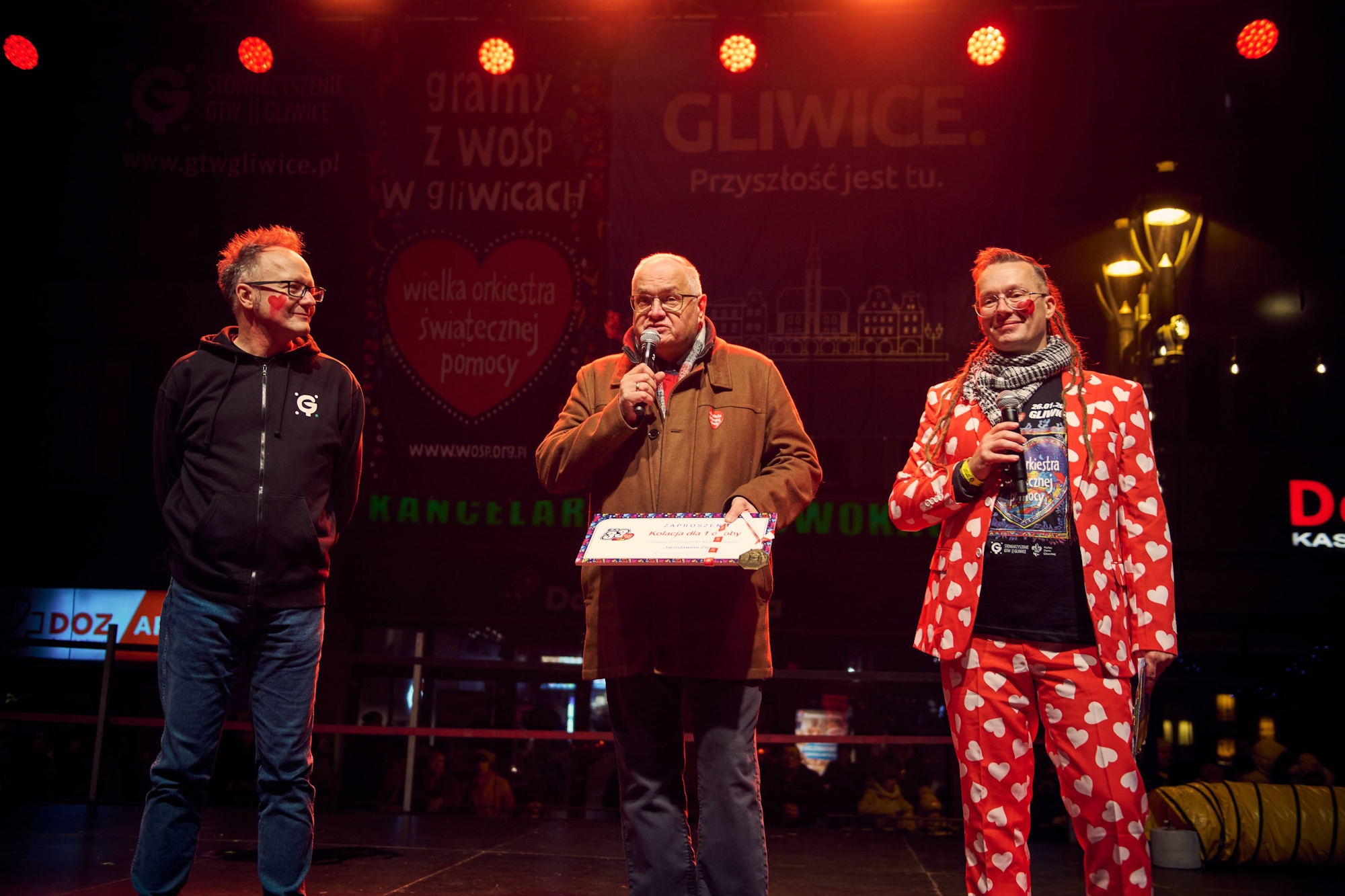 Fot. M. Buksa/UM w Gliwicach Dwóch prowadzących, jeden w czerwonej marynarce z serduszkami, i wiceprezydent Gliwic Jarosław Zięba na scenie