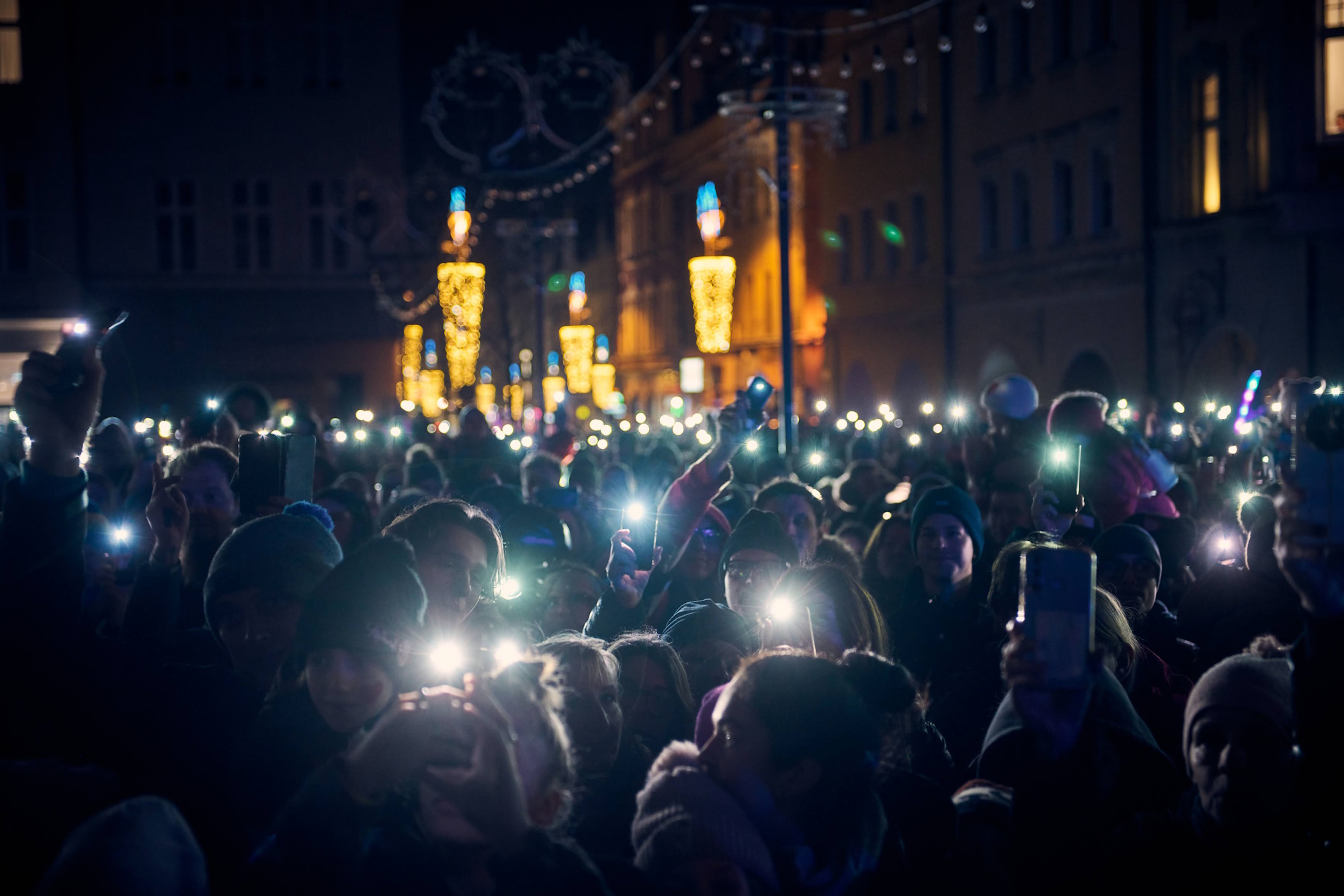 Fot. M. Buksa/UM w Gliwicach Ludzie z zapalonymi latarkami w smartfonach świecą nad siebie