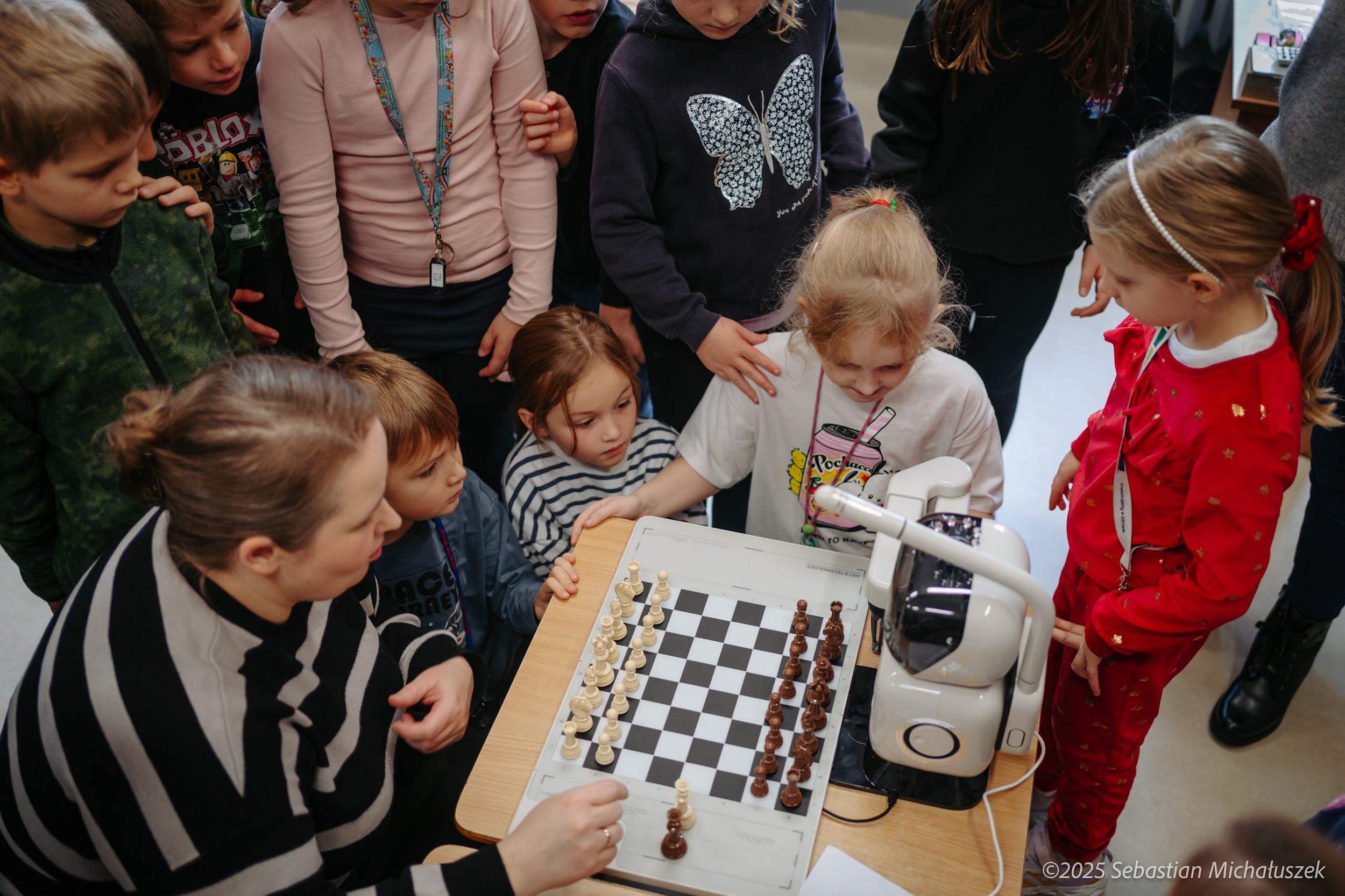 Dzieci grające w szachy z robotem