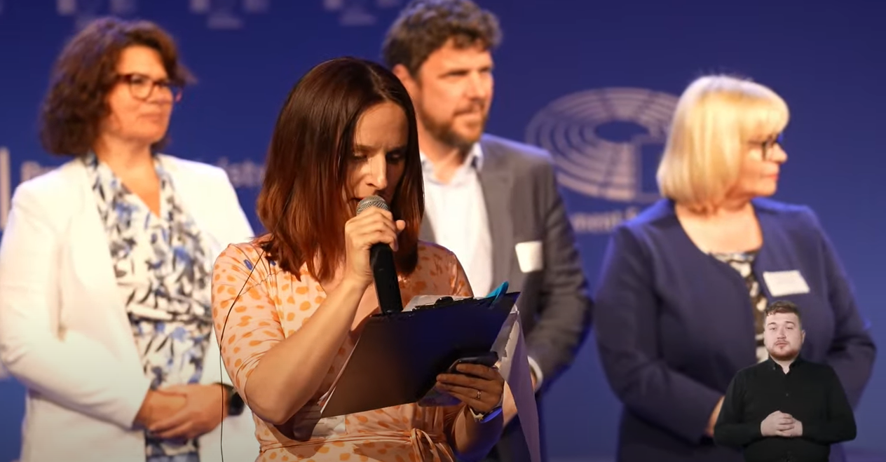 Zrzut ekranu z konferencji online/ Komisja Europejska w Polsce Prowadząca konferencję wyczytująca nazwiska przedstawicieli miast członkowskich GZM