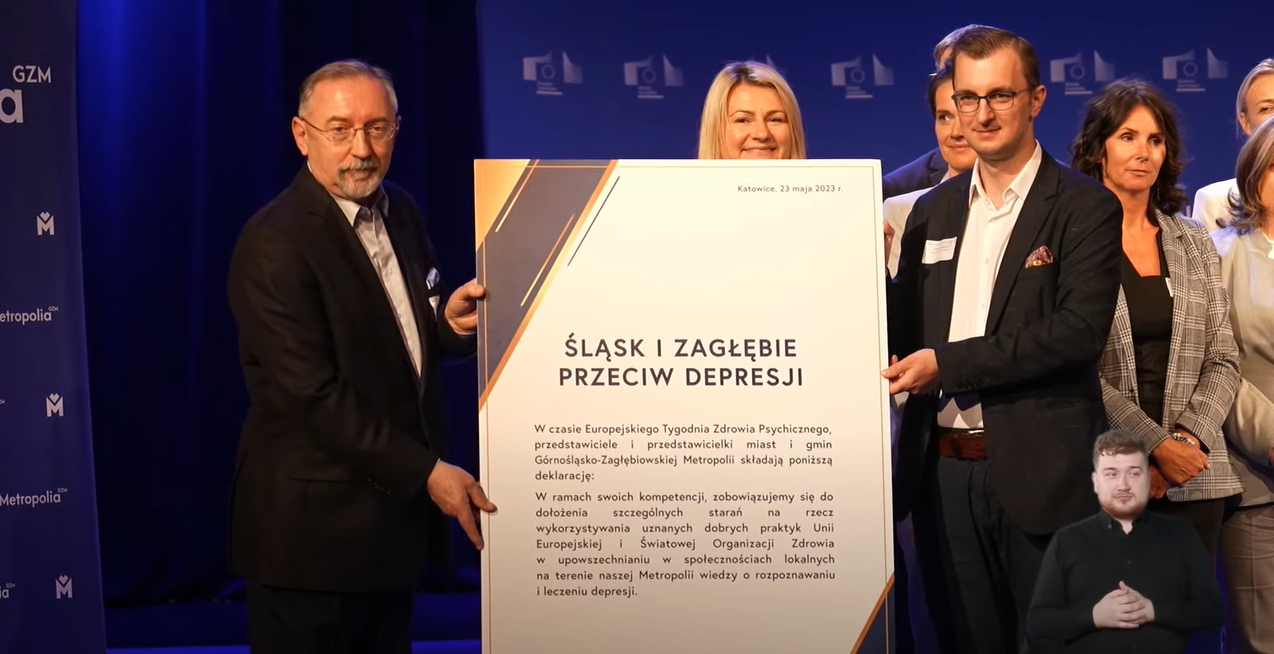 Zrzut ekranu z konferencji online/ Komisja Europejska w Polsce Zastępca prezydenta Katowic i jeden z prelegentów trzymający deklarację przeciw depresji