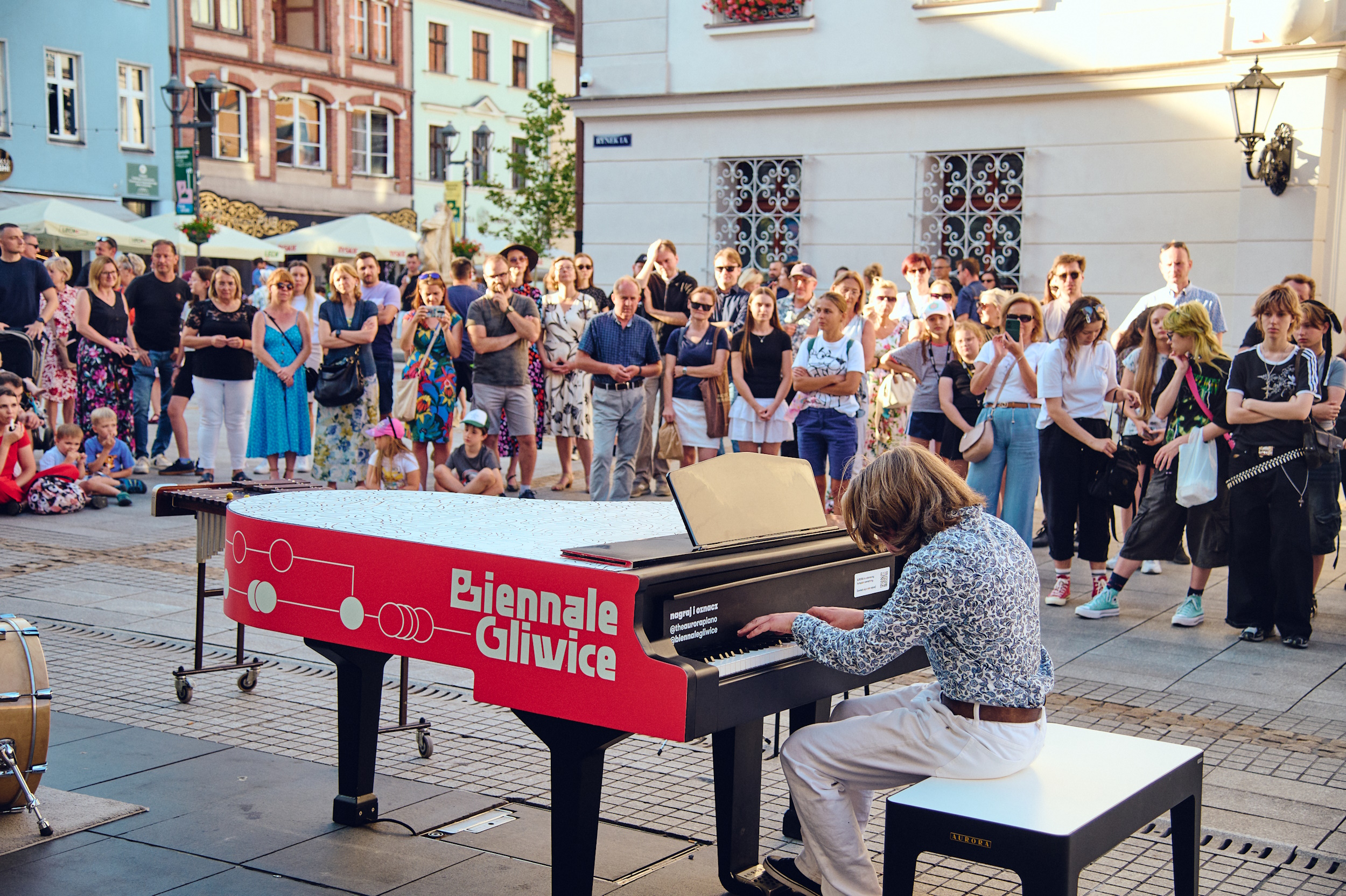 Chłopak grający dla publiczności na festiwalowym fortepianie