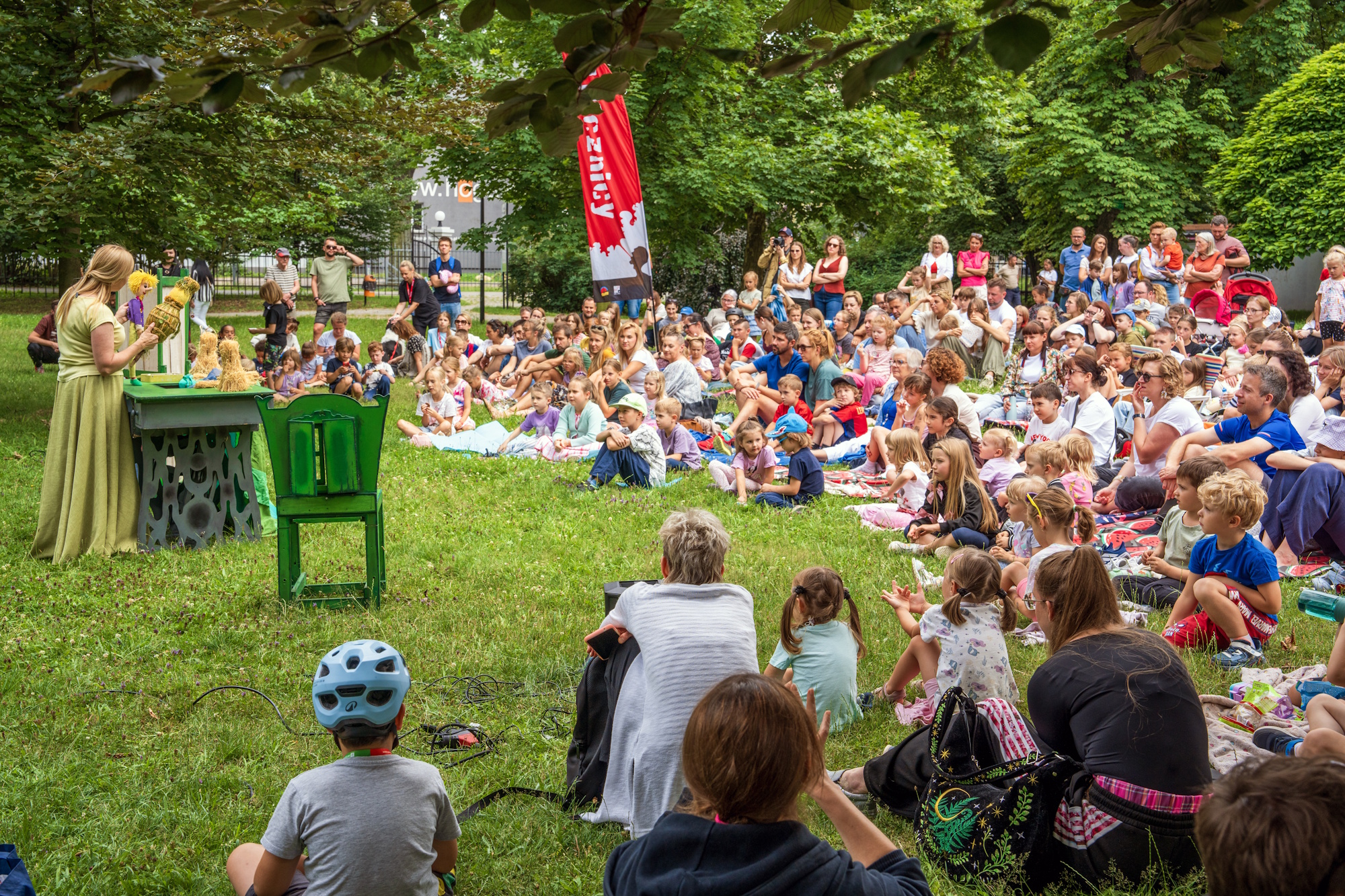 Ludzie w parku ogladają spektakl