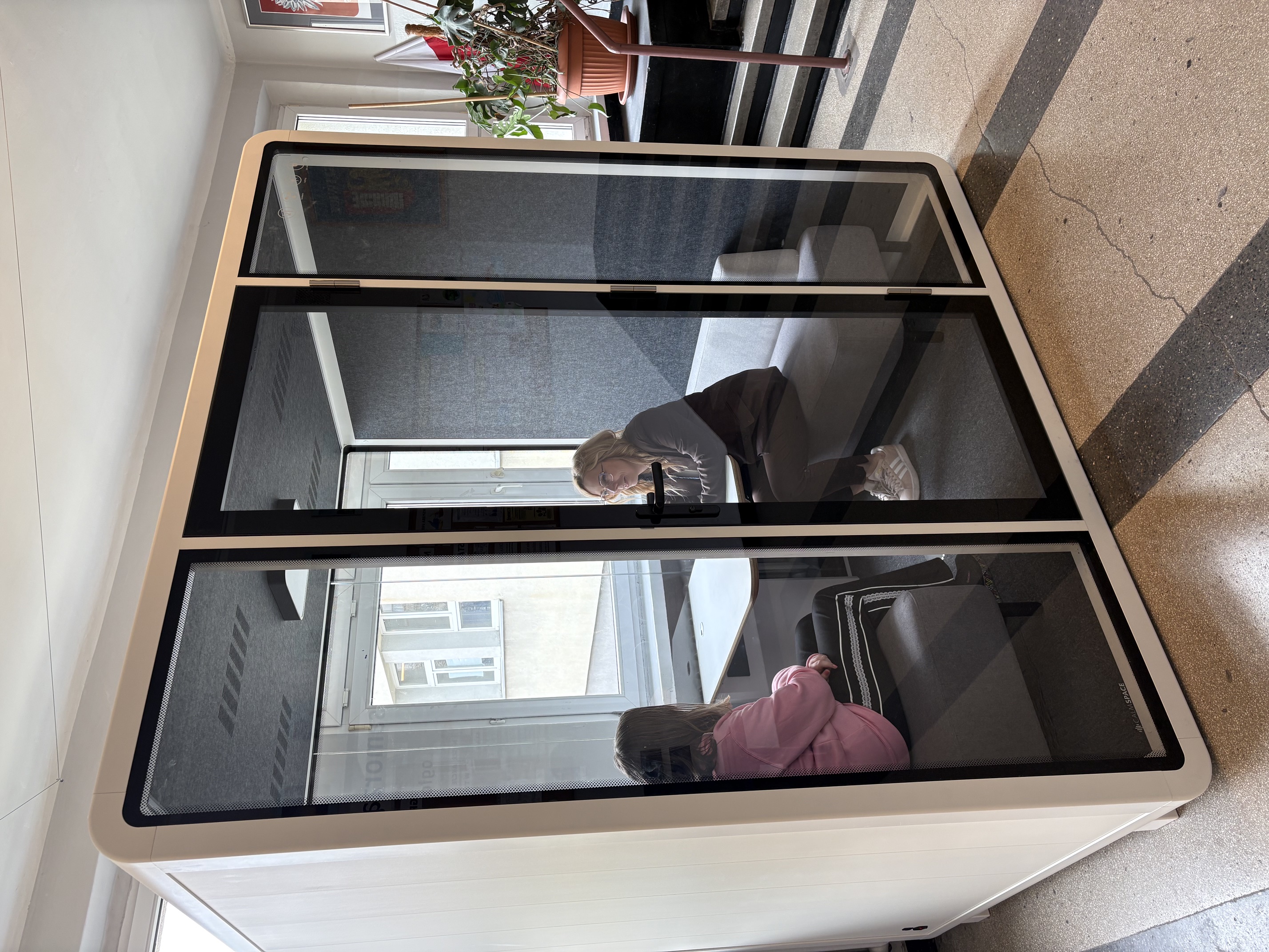 Nauczycielka siedząca z uczennicą w kabinie akustycznej