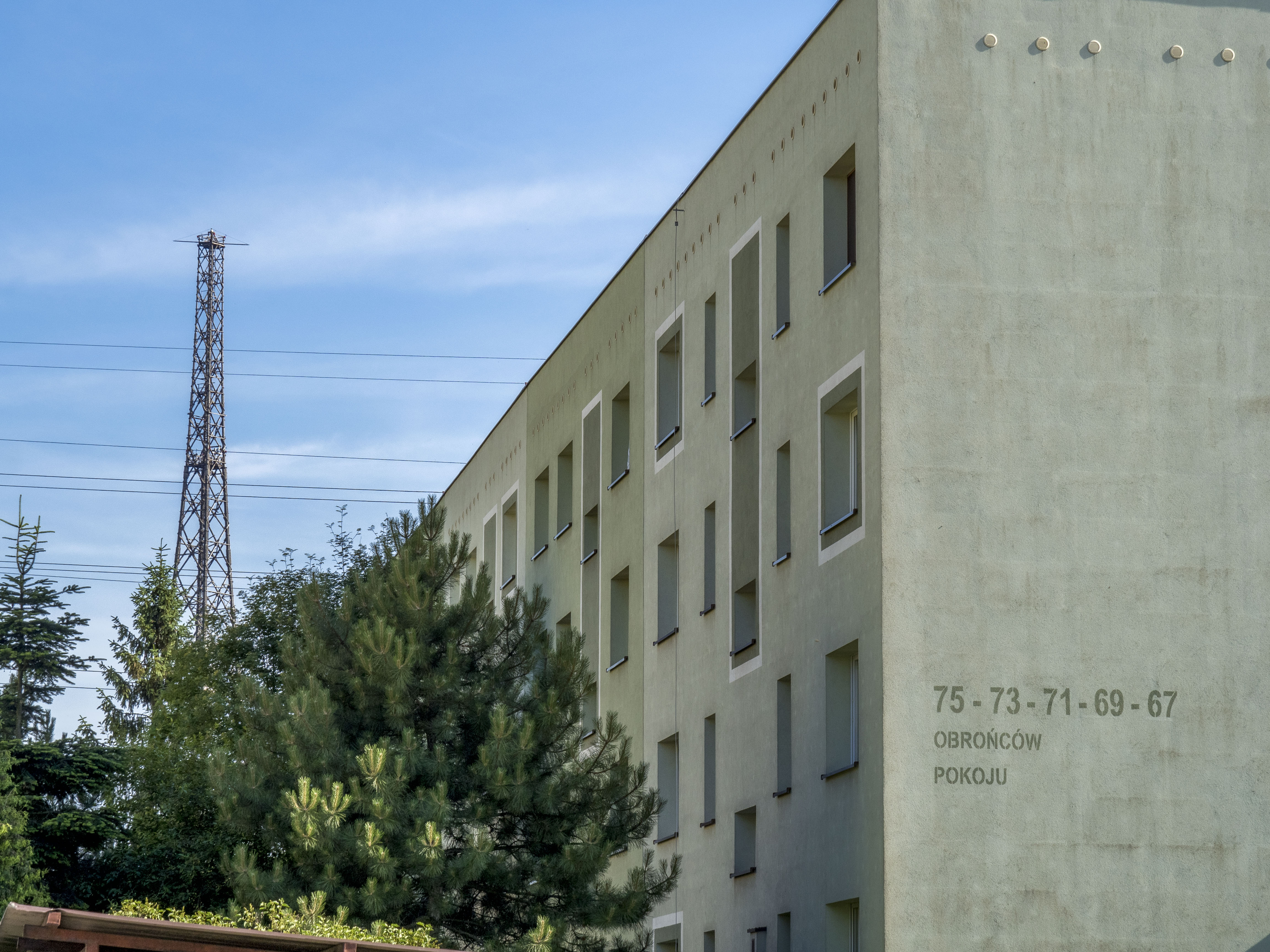 blok mieszkalny, obok drzewo i wtle radiostacja Gliwice