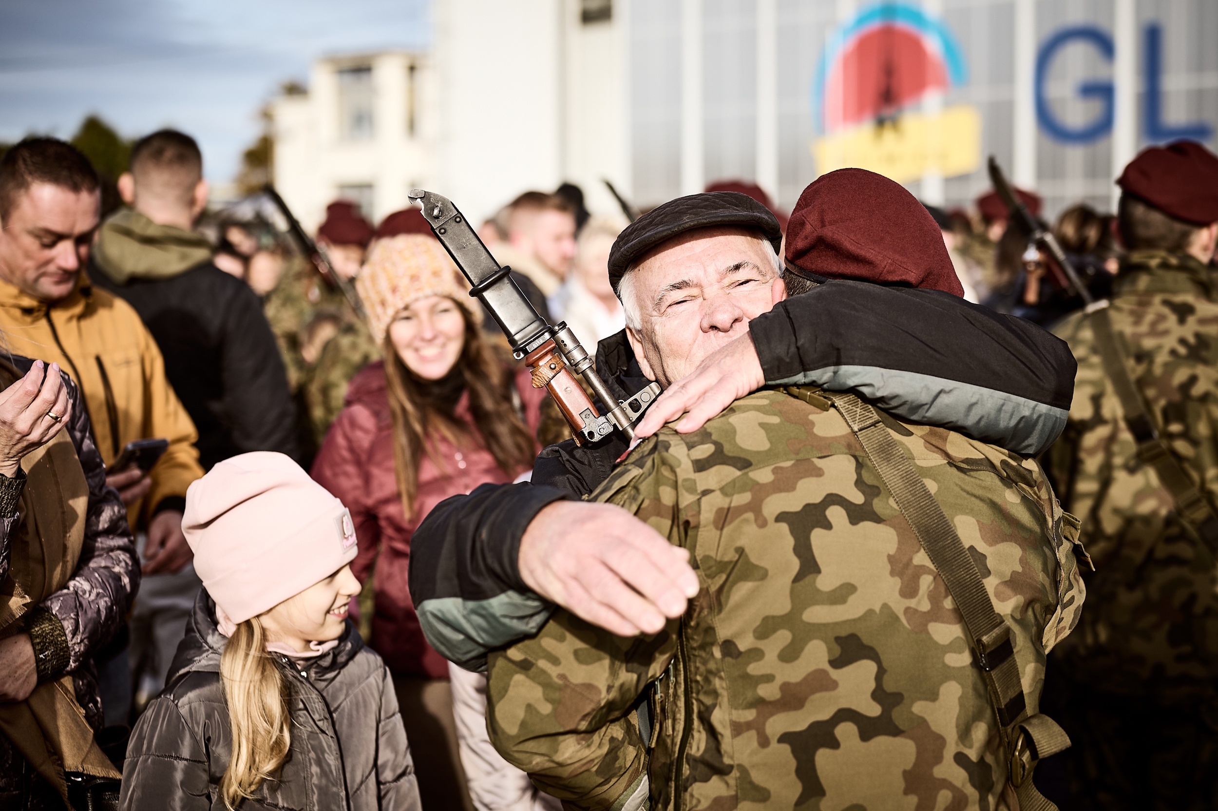 Starszy pan przytulający młodego żołnierza