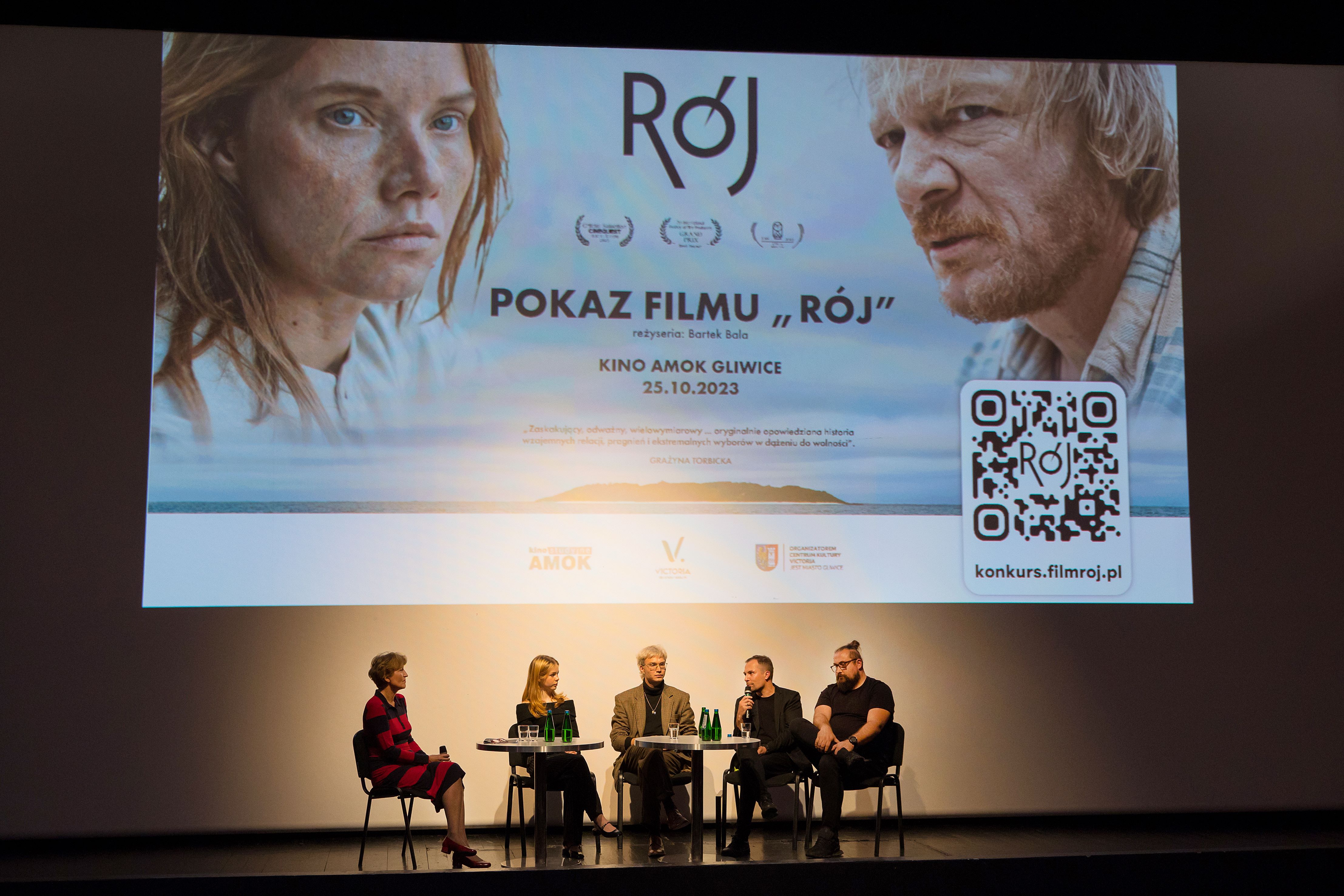 Rozmowa na scenie, w tle plakat "Roju"