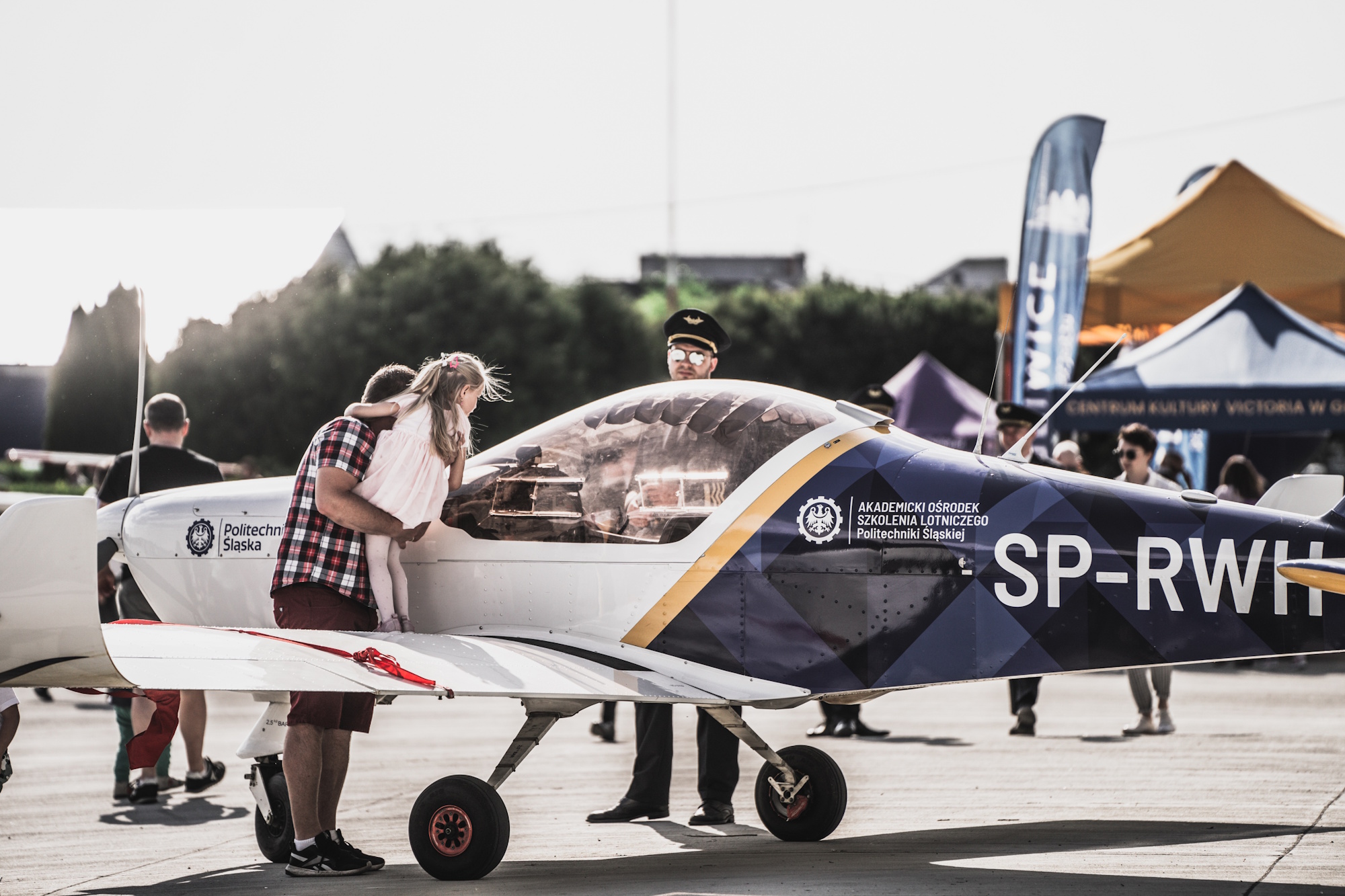 dziewczynka na rękach opiekuna przy samolocie